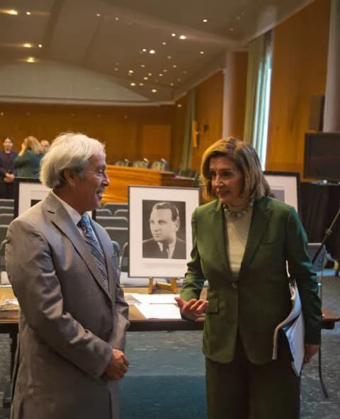 Philip Auerbach speaking with Speaker Emerita Nancy Pelosi at a hearing room event